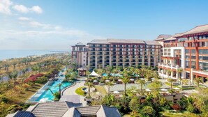 Un resort con piscina, varias construcciones y vista al mar.