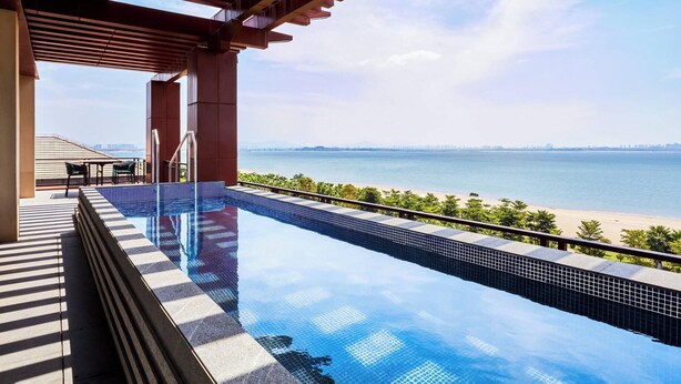 Una piscina infinita con vista a la playa y al océano.