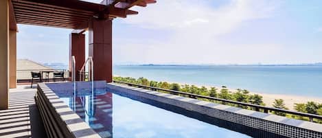 Una piscina infinita con vista a la playa y al océano.