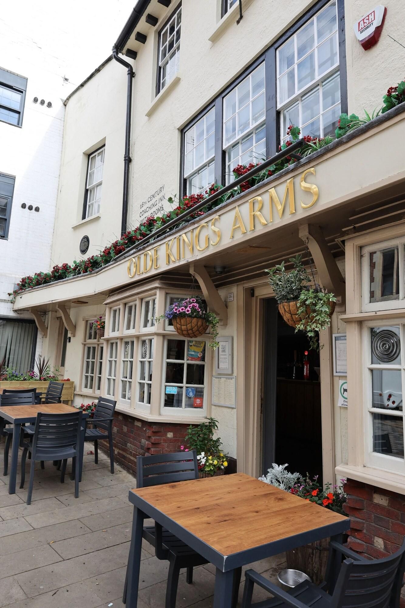 Een pub genaamd 'The Old Kings Arms' met terras en bloembakken.