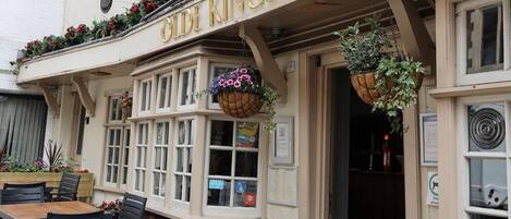 A pub named 'The Old Kings Arms' with outdoor seating and hanging flower baskets.