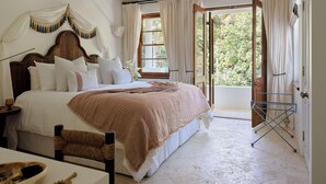 A bedroom with a large bed, a ceiling fan, a window with curtains, and a view of greenery outside. - Raes on Wategos  (Byron Bay)