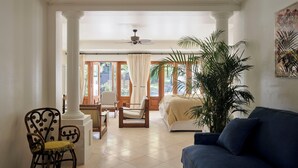 A spacious living room with a large window, a ceiling fan, and a blue sofa. - Raes on Wategos  (Byron Bay)