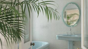 A bathroom with a bathtub, sink, and mirror.