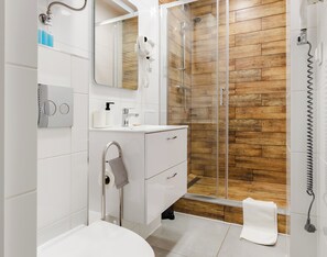 A modern bathroom with a shower, a toilet, a sink, and a mirror. - Głęboka Harmony Studio (Gdańsk)