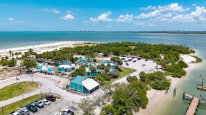 Un hôtel situé sur la côte, composé de plusieurs bâtiments, doté d’un parking et offrant une vue sur la plage.