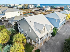 A coastal residential area with multi-story houses, some with balconies, and a beach in the background. - Endless Summer - 3BR Gulf Shores Ocean View Beach House (Gulf Shores)