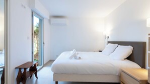 Ein modernes Schlafzimmer mit einem großen Bett, Nachttischen und einer Bank.