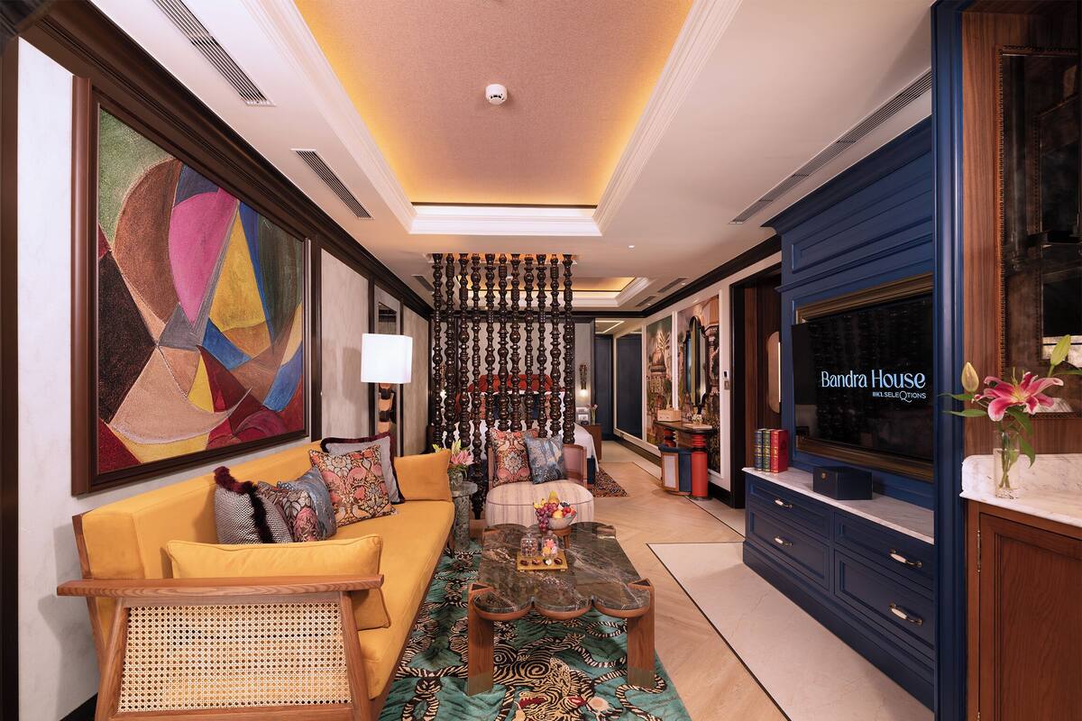 A spacious living room with a sofa, coffee table, and a large abstract painting.