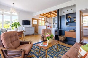 Uma sala de estar aconchegante com lareira, assentos confortáveis e uma televisão.