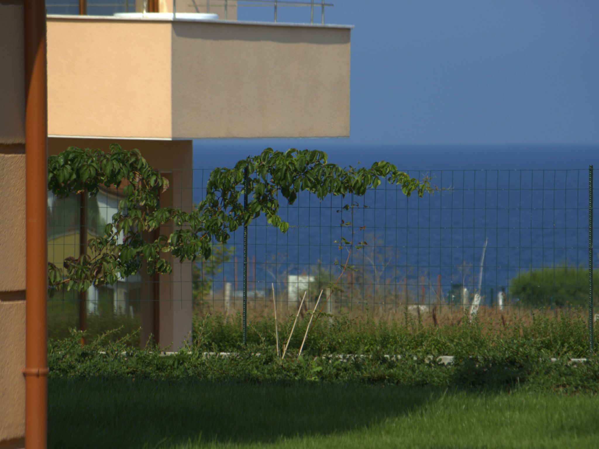 A modern building with a flat roof and a view of the sea.