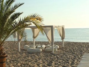 A beach setting with a white canopy structure, bean bags, and a wooden deck. - Apartment Una by Interhome (Lozenets)