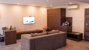 Ein modernes Wohnzimmer mit Flachbildfernseher, einer Couch, einem Couchtisch und einem Schrank.