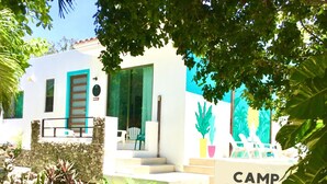 Un bâtiment moderne avec un mur en pierre, un escalier et une enseigne sur laquelle on peut lire « CAMP AKUMAI ».