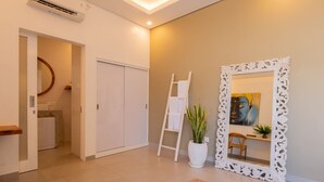 A modern interior with a white wardrobe, a mirror with an ornate frame, and a potted plant. - Haus Moana by Interhome (Seminyak)
