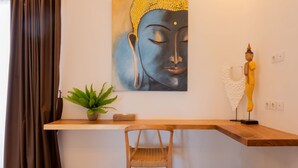 A room with a wooden desk, a chair, a Buddha statue, a painting, and a potted plant. - Haus Moana by Interhome (Seminyak)