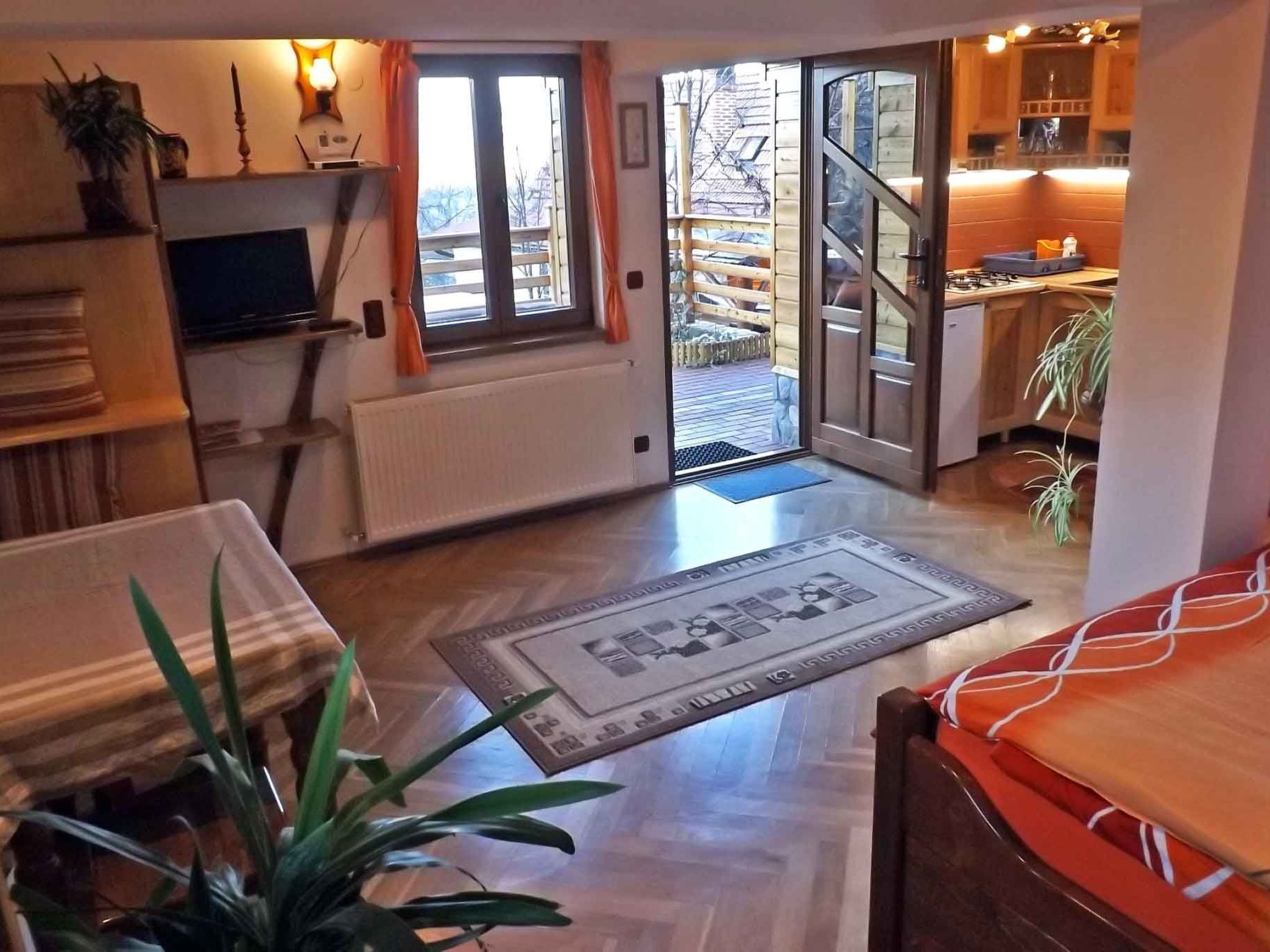 Un salon chaleureux avec une cheminée, un téléviseur et un coin repas agrémenté d’un tapis.