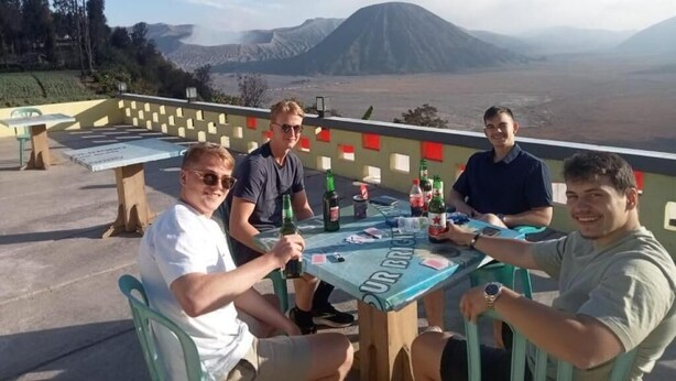 A group of people seated at a table with a view of a mountain. - Tengger Bromo Villa (Ngadisari)