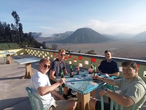 Eine Gruppe von Personen sitzt an einem Tisch mit Blick auf einen Berg.