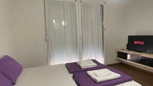 A hotel room with a bed, a TV, and a window with curtains. - Wohnung "Stefea Center Apart" by Interhome (Ohrid)