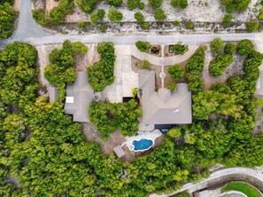 An aerial view of a residential property with a swimming pool, multiple driveways, and lush greenery. - Casita W Stunning Views (Austin)