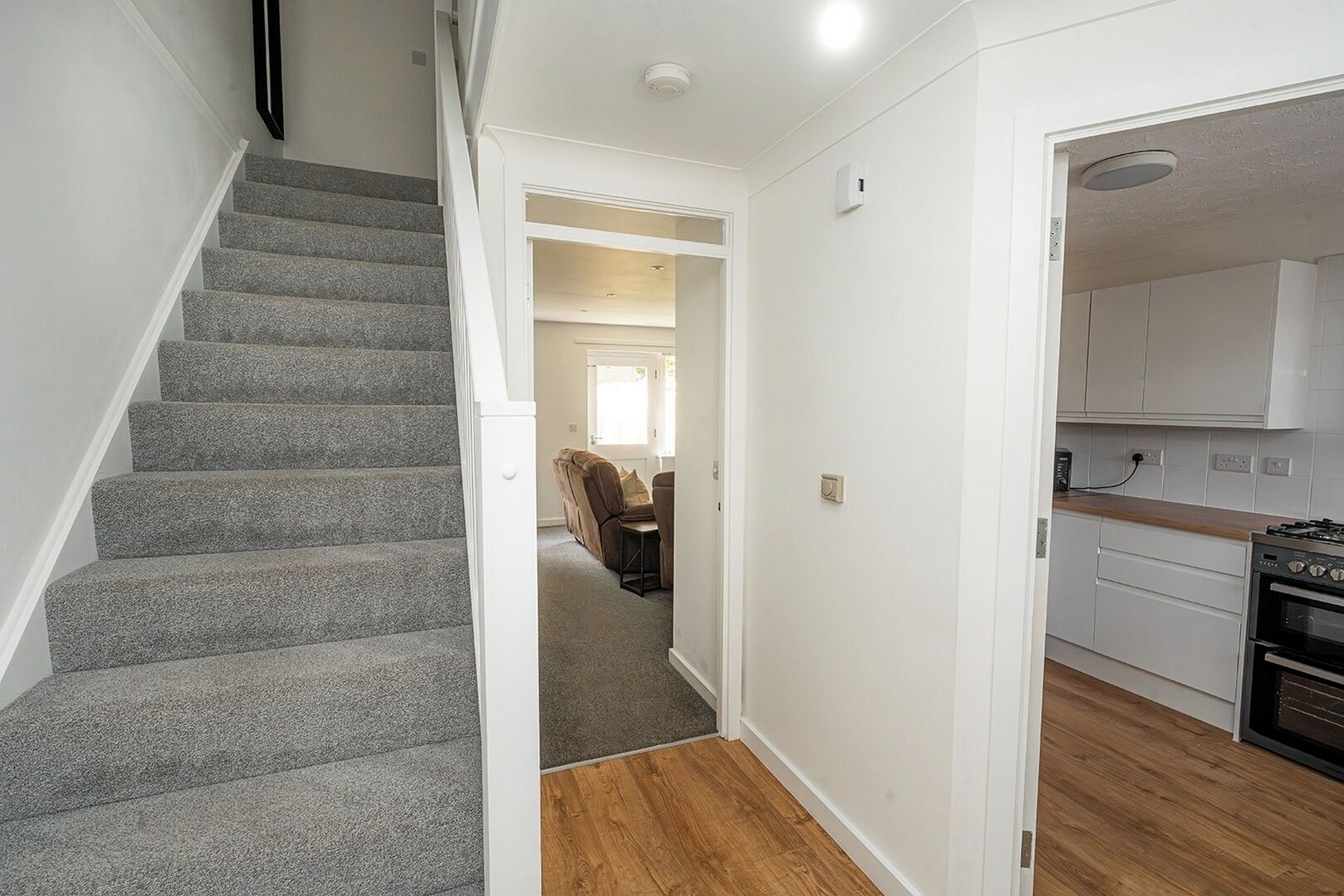 A staircase leading to a living area with a kitchen and a dining area.