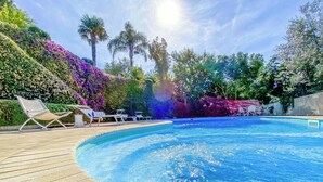 Ein Schwimmbecken mit Liegestühlen und einer Holzterrasse.