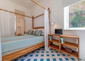A room with a bed, a laptop on a wooden nightstand, and a window with a view of greenery. - Casa Mareluna, Elegance in the Heart of Sorrento (Sorrento)