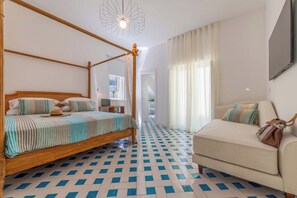 A room with a four-poster bed, a sofa, and a patterned floor. - Casa Mareluna, Elegance in the Heart of Sorrento (Sorrento)