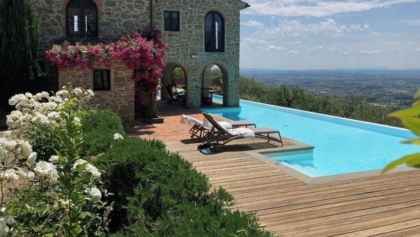 A stone building with a swimming pool, surrounded by lush greenery and flowers. - Villa Armonia, Tranquillity with Panoramic Views (Larciano)