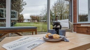 A table with a newspaper, a plate of biscuits, and a coffee pot. - 1 Box Iron Cottage, Shotley (Shotley)