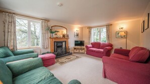 A living room with a fireplace, two green sofas, two red sofas, and a television. - 1 Box Iron Cottage, Shotley (Shotley)