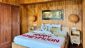Une chambre à coucher décorée dans un style rustique, avec un lit, deux tables de chevet, un tableau accroché au mur et un plafond en bois.