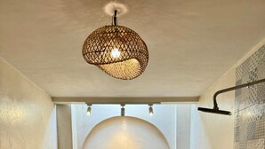 Une salle de bain moderne avec une baignoire sur pieds, une douche et un luminaire décoratif.