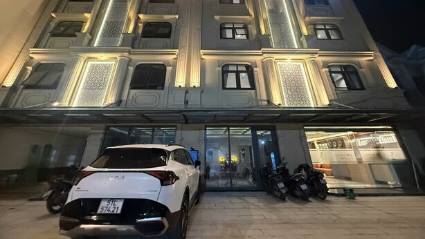 La façade de l’hôtel Leonora, avec une voiture blanche garée devant.