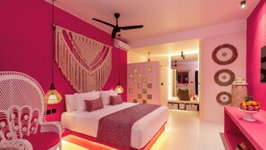 Ein modernes Schlafzimmer mit einem Bett, einem weißen Stuhl, einem Deckenventilator und einer Wand mit Dekorationen.