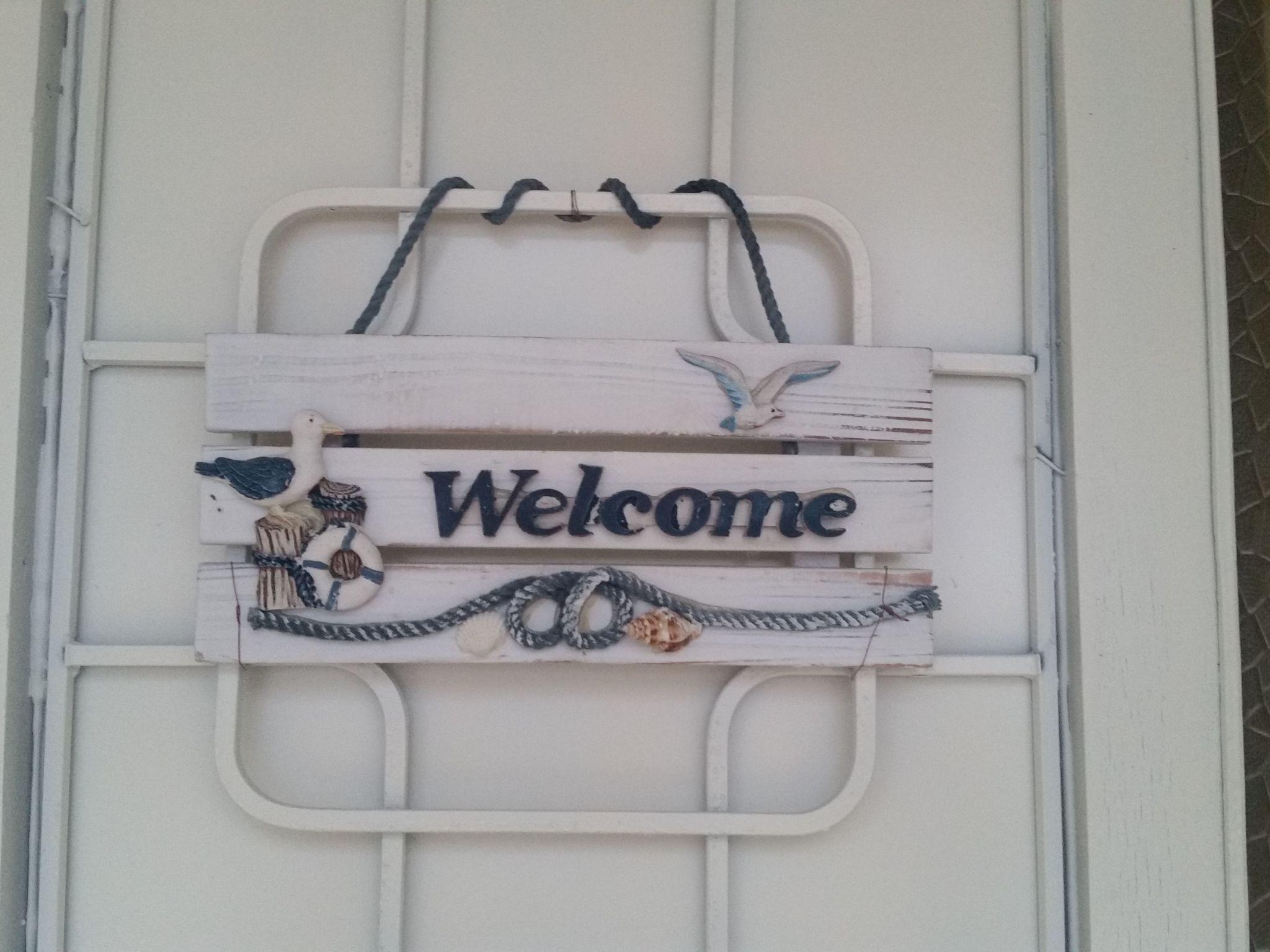A welcome sign with nautical decorations.