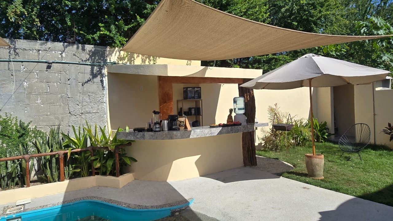 Een zwembadgedeelte met een bar, terras en een fontein.