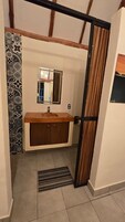 Un baño con tocador de madera, un espejo y azulejos decorativos en las paredes.