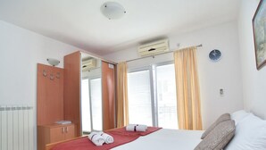 A hotel room with a bed, a wardrobe, a mirror, and a window with curtains. - Studio-Apartment mit Balkon by Interhome (Tivat)