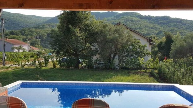Ein Pool mit zwei Liegestühlen und Blick auf eine Berglandschaft.