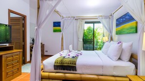 A room with a bed, a television, and a window with curtains.