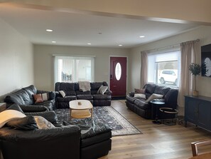 A living room with two black leather sofas, a coffee table, and a patterned rug. - Marina House - Lake Life and Shirley's Treats Next Door (Starbuck)