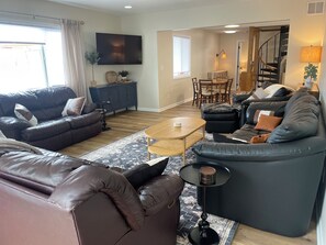 A living room with a sofa set, a coffee table, and a dining area with chairs and a table. - Marina House - Lake Life and Shirley's Treats Next Door (Starbuck)
