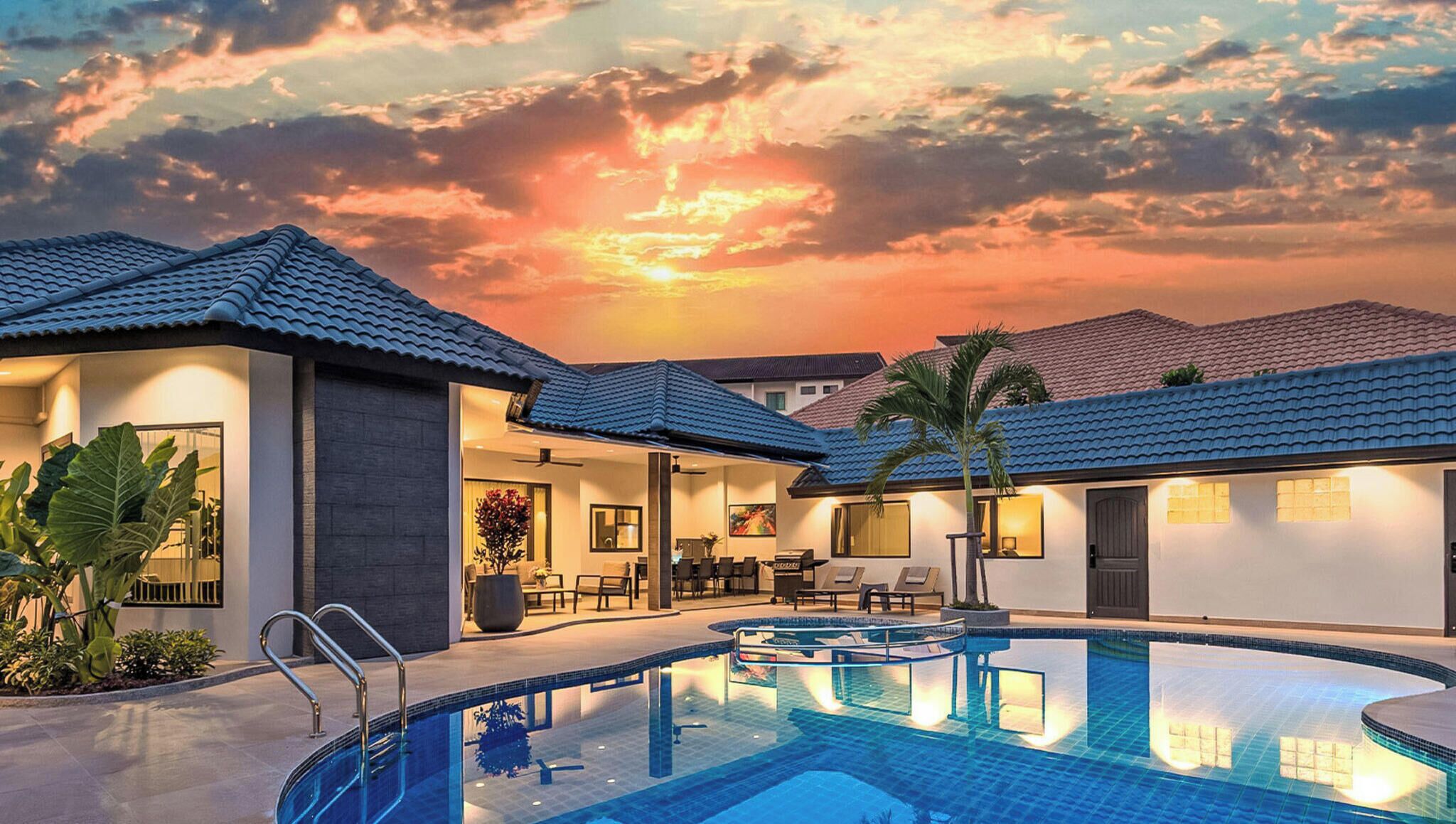 Ein Resort mit Pool, Außenbereich und Blick auf den Sonnenuntergang.