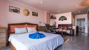 Une chambre à coucher avec un grand lit, un bureau, une chaise et une porte.