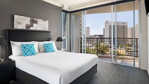 A hotel room with a large bed, a view of the city through a balcony, and a modern design. -  Mantra Towers of Chevron Holiday in Paradise (Surfers Paradise)