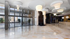 A spacious lobby with a polished floor, large glass doors, and modern pendant lighting. -  Mantra Towers of Chevron Holiday in Paradise (Surfers Paradise)