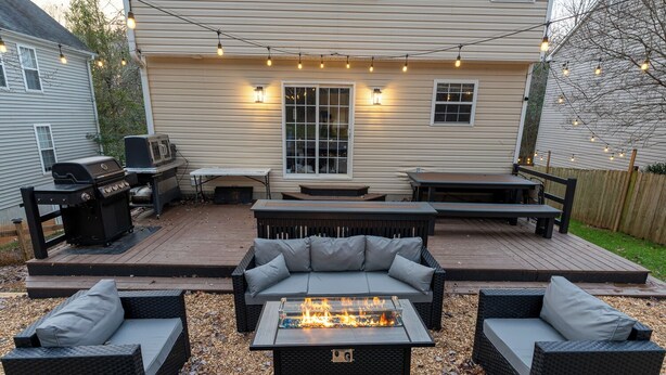 A backyard patio with outdoor furniture, a fire pit, and string lights. - 3 Bedroom Homestead Getaway - Walkable Carrboro, Minutes to UNC (Carrboro)