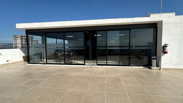 A modern building with a flat roof, large glass doors, and a fire extinguisher on the wall. - Federalta Sky Life Apartment in Calzada del Federalismo (Zapopan)